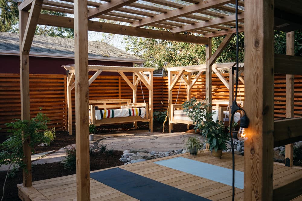 Cozy outdoor seating area with wooden frames, plants, and a peaceful atmosphere.